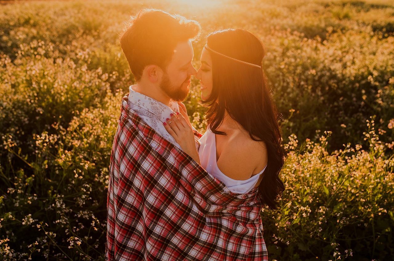 Couple amoureux dans un champ de fleurs au coucher du soleil
